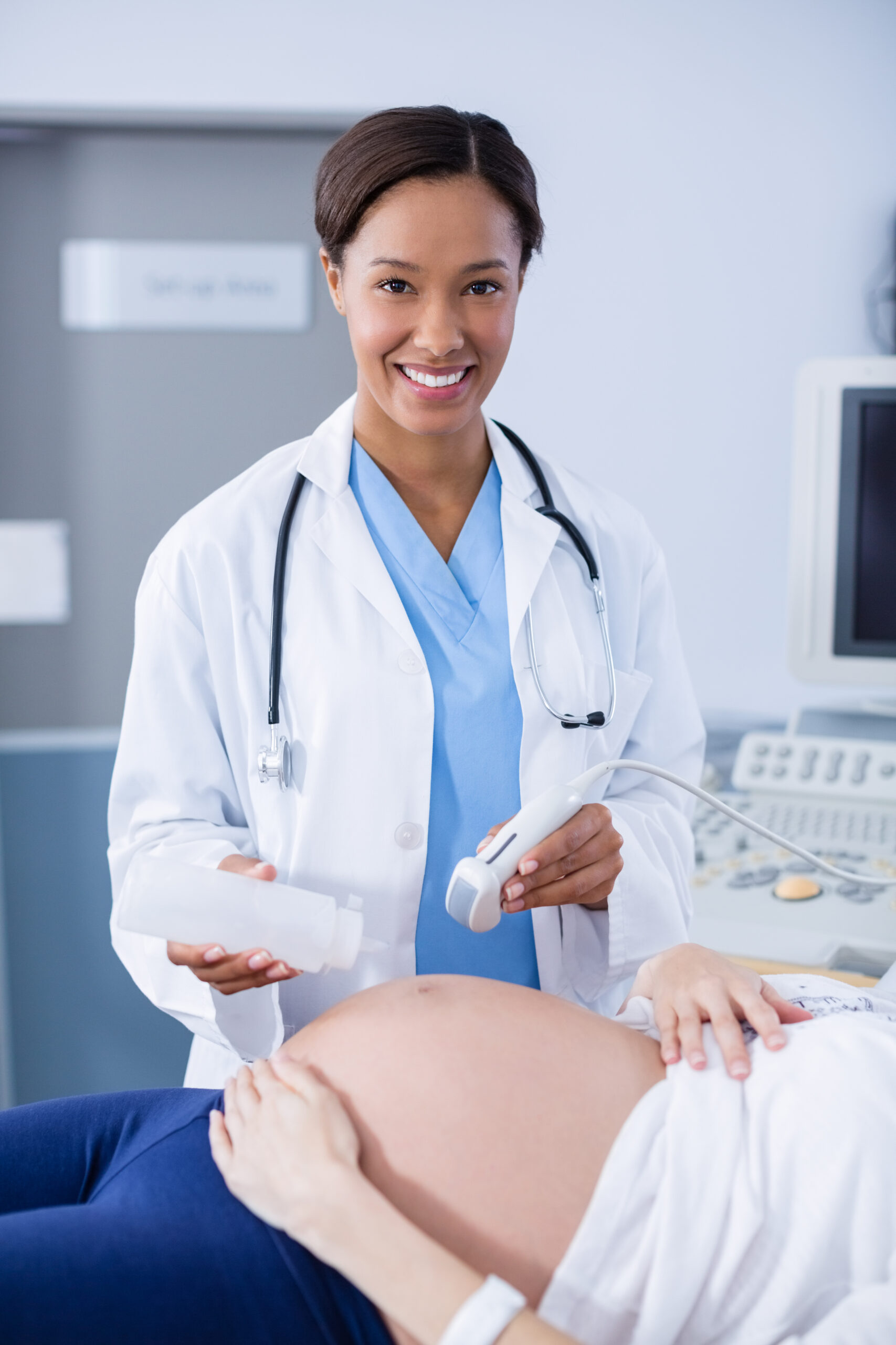 Doctor doing ultrasound scan for pregnant woman in hospital